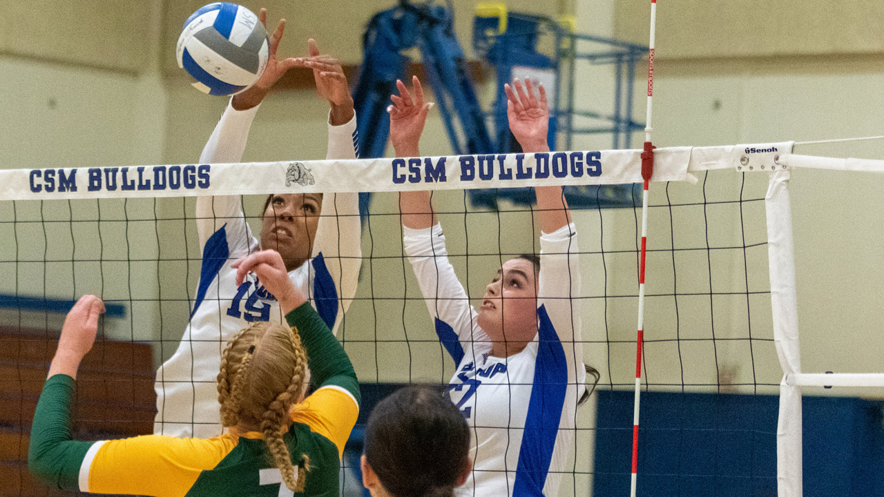 Aniyah Hall (19) and Olivia Cooper (12) go up for a block in the win over Feather River. (Photo by Ronald Rugel)